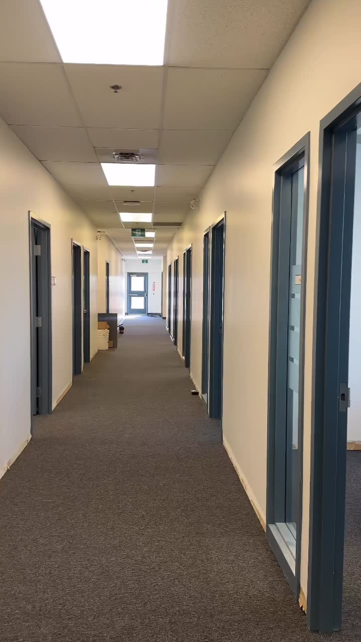 Completed glass-partitioned office corridor at Zurn Canada